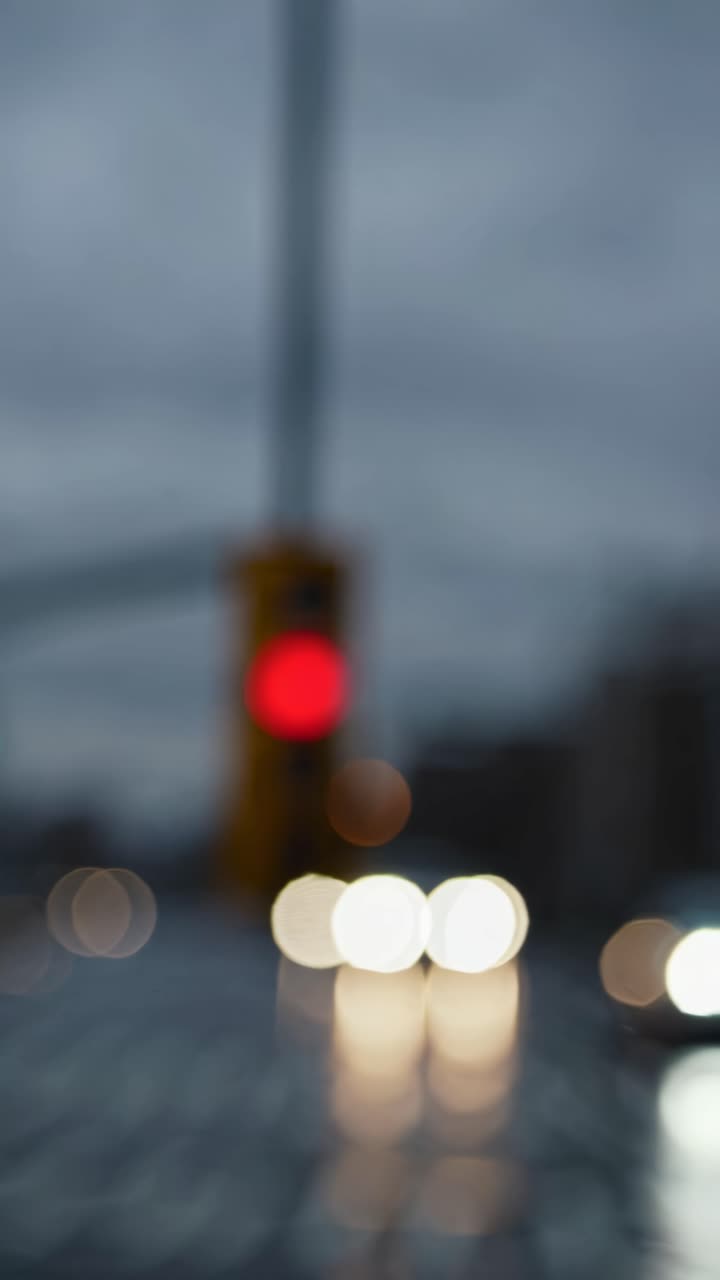 Blurred urban scene with bokeh lights, shot from a low angle. The video captures a dreamy, abstract