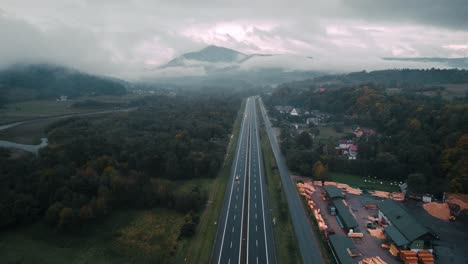 aerial shot of highway and cars covered in fog