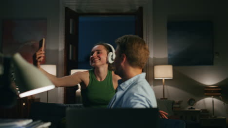 Carefree-woman-taking-selfie-husband-closeup.-Laughing-guy-videocalling-laptop