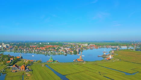 네덜란드 암스테르담 근처 에 있는 강, 풍차, 그리고 배경 에 있는 도시 인 zaanse schans 의 아름다운 풍경