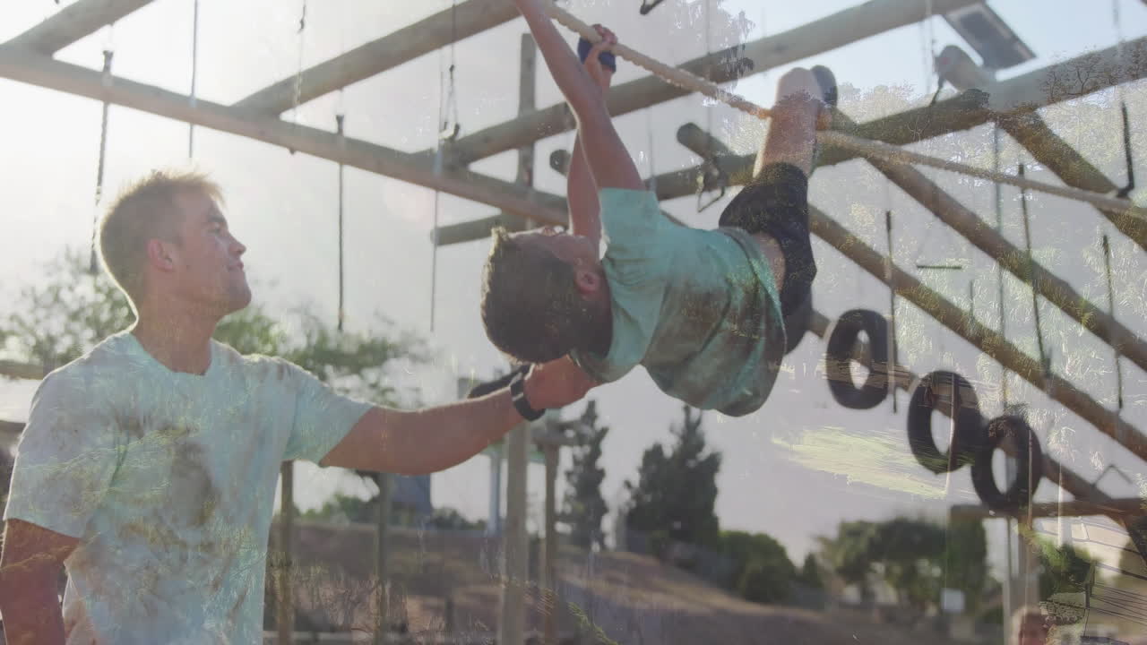 Helping child on monkey bars, father at playground with animation mural