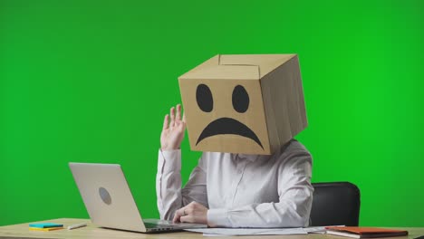 person with cardboard box head in office setting