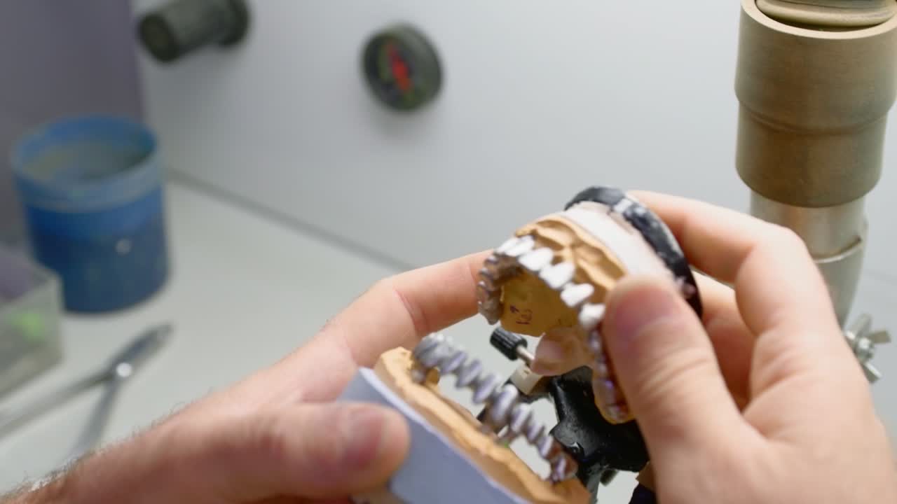 técnico dental trabaja en su taller y hace dientes artificiales para la odontología