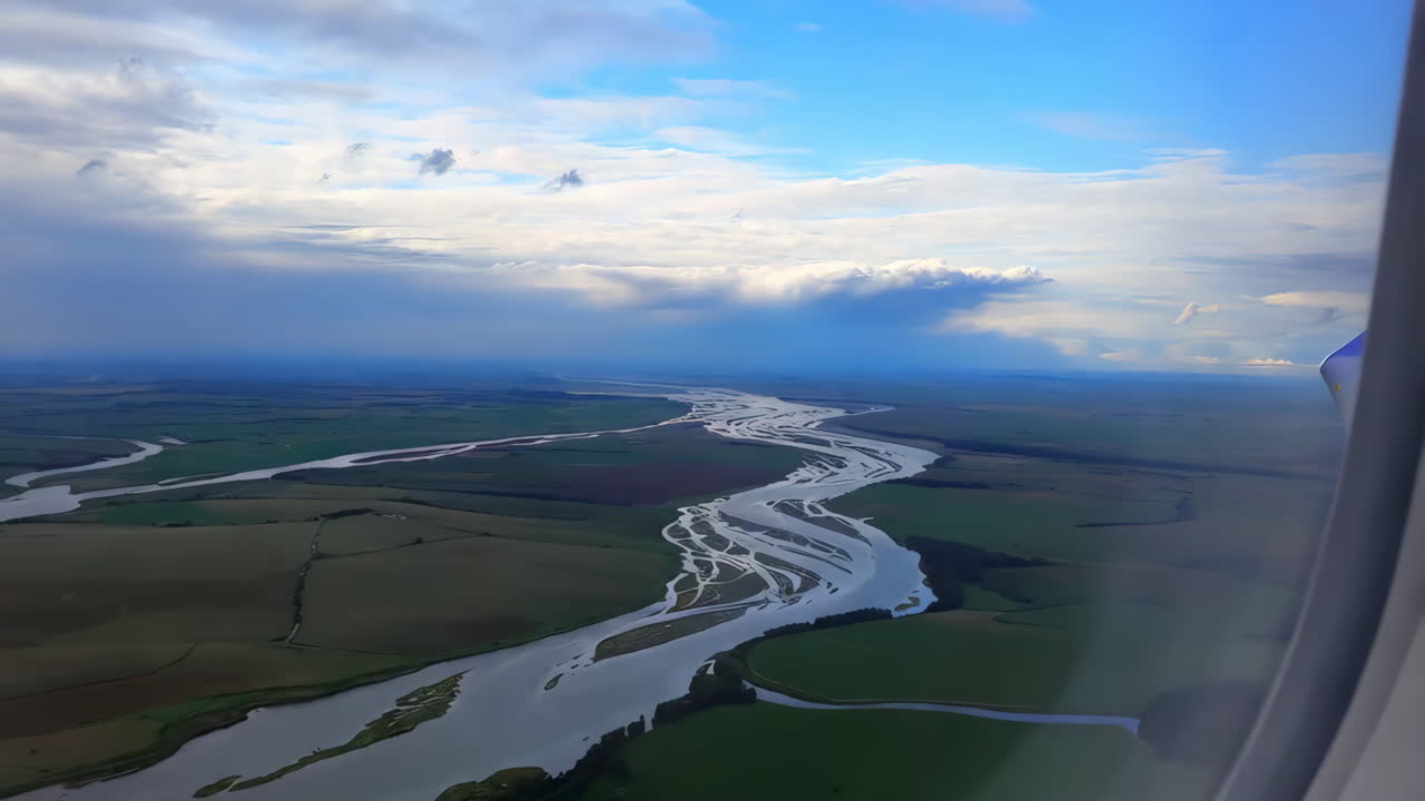 Aerial View of Braided River and Green Landscape from Airplane Window