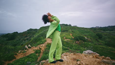 mujer bailando el crepúsculo al aire libre en la colina verde. bailarina de chica actuando verticalmente