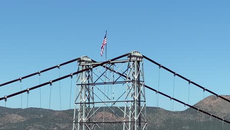 usa flag on suspension tower supporting the bridge over royal gorge, colorado