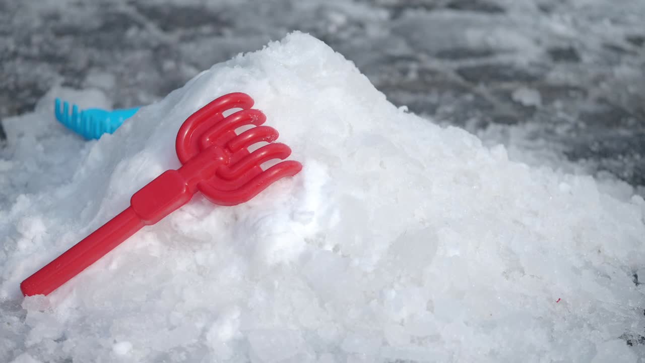 Red Plastic Snow Shovel on a Snow Pile