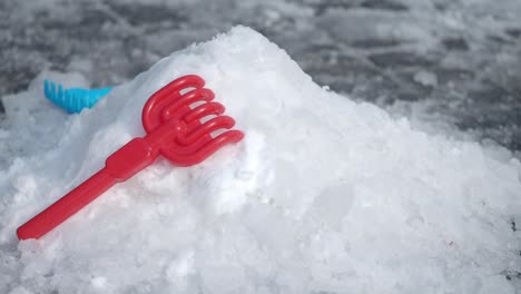 red plastic snow shovel on a snow pile