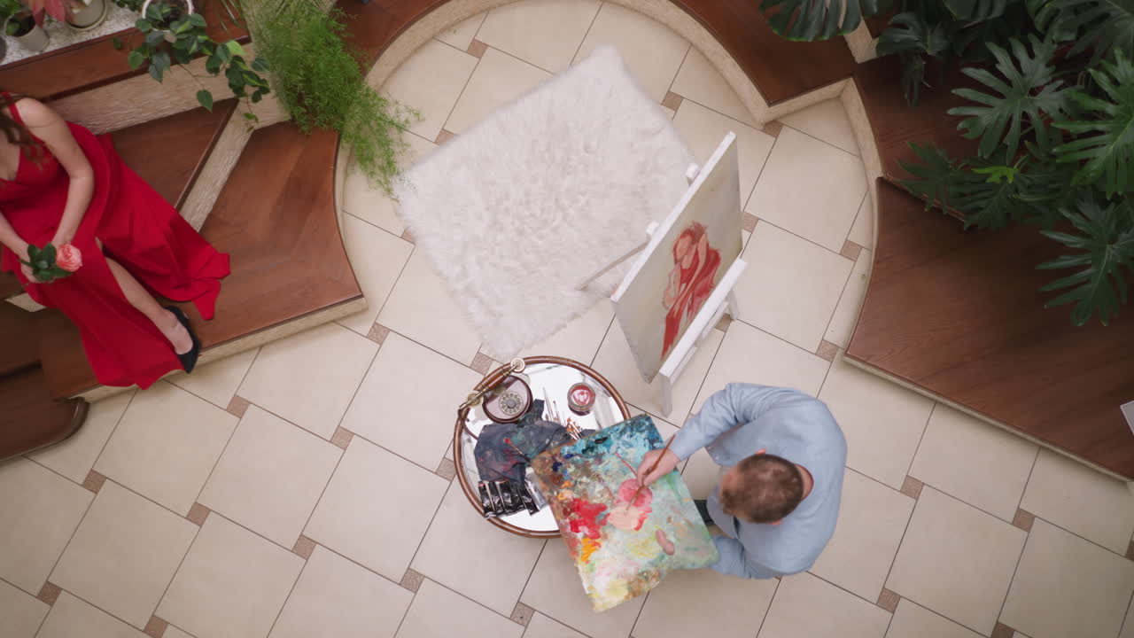 el artista agrega agua para pintar en el dibujo de modelo en vivo. el pintor profesional hace una sombra rosa suave para dibujar el retrato de la mujer en la galería. el hombre crea una imagen