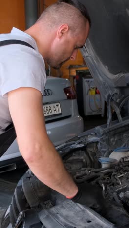 man working on a car engine in a garage