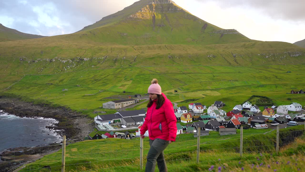페로 제도 에 있는 에이스투로이 의 아름다운 게고브 마을 과 산 근처 에서 하이킹 하는 여자