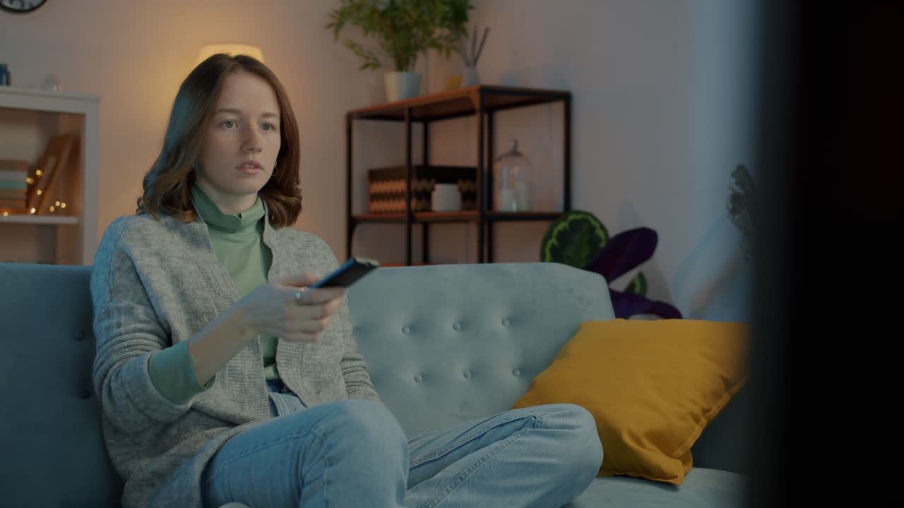 Donna che guarda e reagisce alla TV