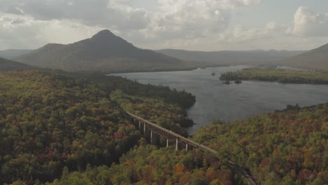 Empujando-Un-Caballete-De-Ferrocarril-Que-Conduce-Hacia-Una-Montaña-Lejana-En-Una-Antena-Forestal-De-Principios-De-Otoño