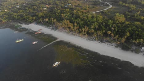 Una-Pequeña-Playa-Local-En-Filipinas-Temprano-En-La-Mañana-Con-Algunos-Botes-Pequeños-Que-Vuelan-Sobre-El-Tiro