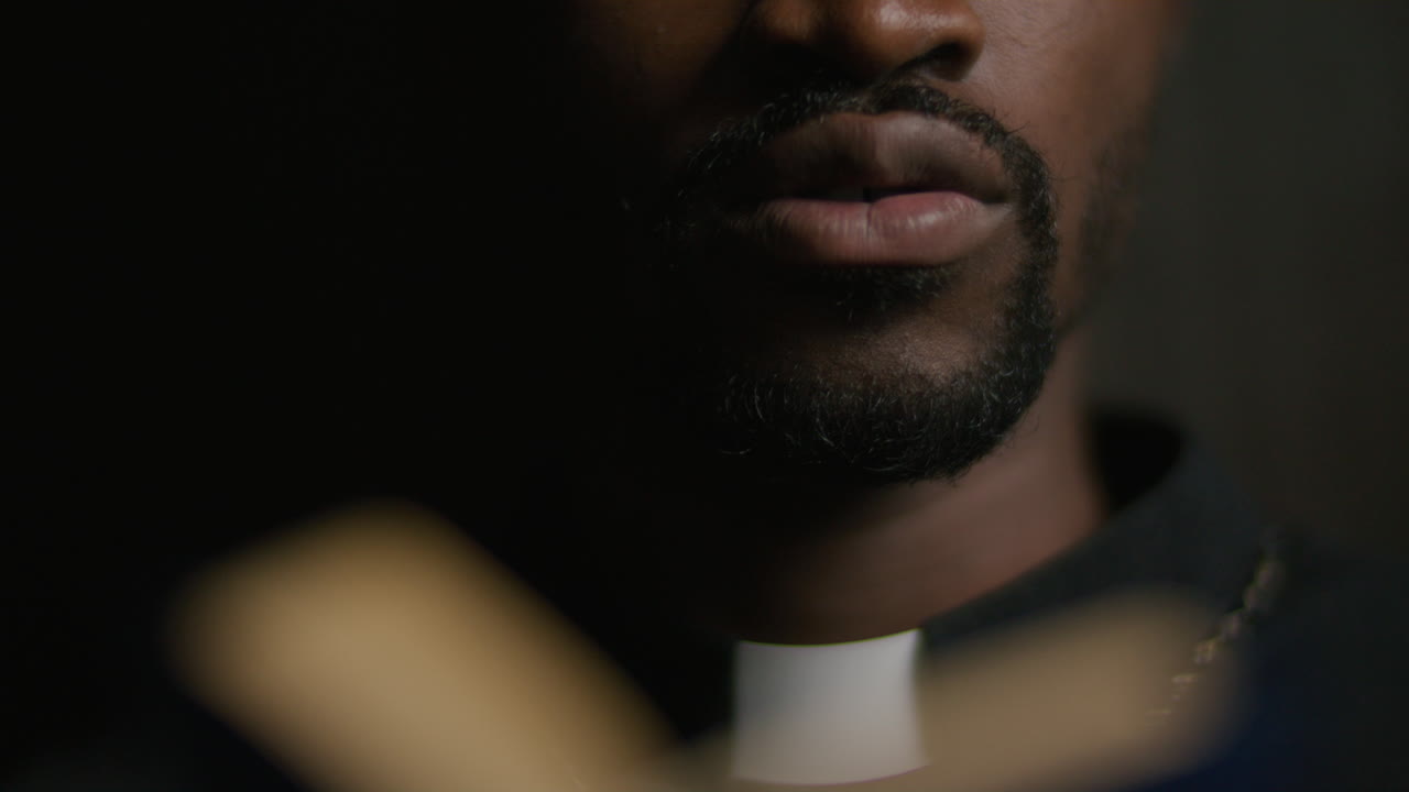 Close-Up of African American Priest Reading from Bible