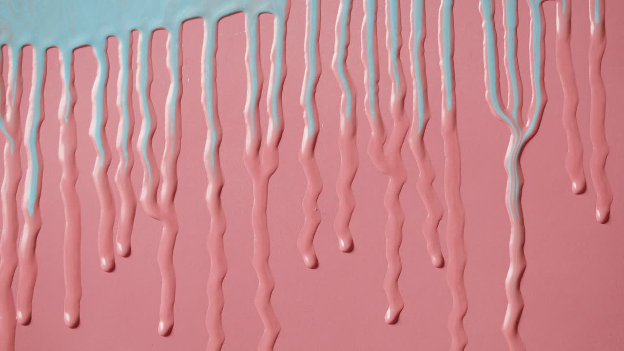 Pastelblauwe verf die druppelt op een roze achtergrond