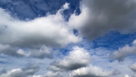 soft fluffy clouds in the amazing azure sky. cirrocumulus and cumulus cloudscape arrives and covers the horizon. low angle view. timelapse.
