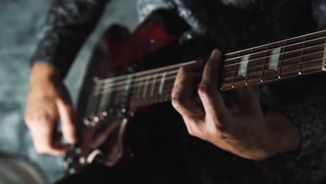 4k close-up of a man playing an electric guitar and changing the volume while holding a chord