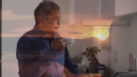 animation of landscape over senior biracial man holding cup and drinking