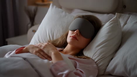 woman sleeping peacefully with an eye mask in bed