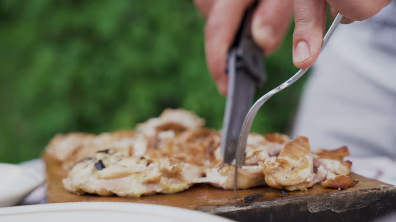 나이프와 포크를 들고 남자 손, 야외에서 신선한 모닥불 스테이크 절단