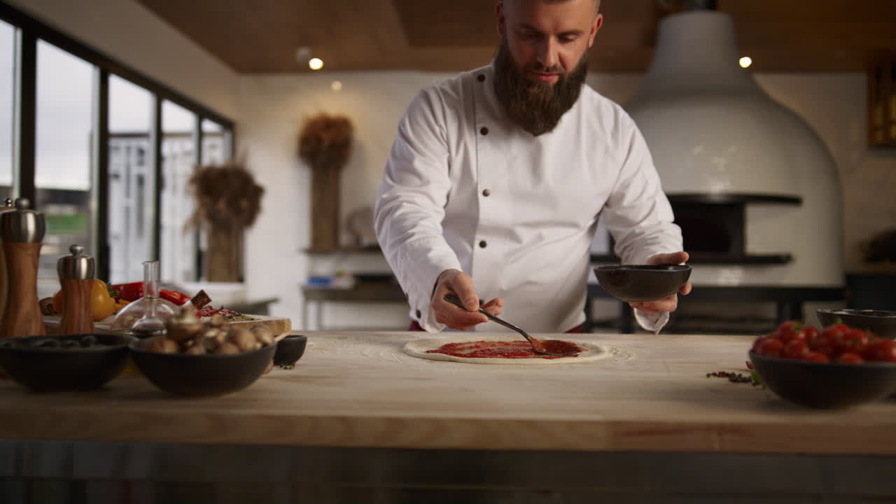 cocinero profesional haciendo pizza en la cocina culinaria. chef hombre extendiendo ketchup.