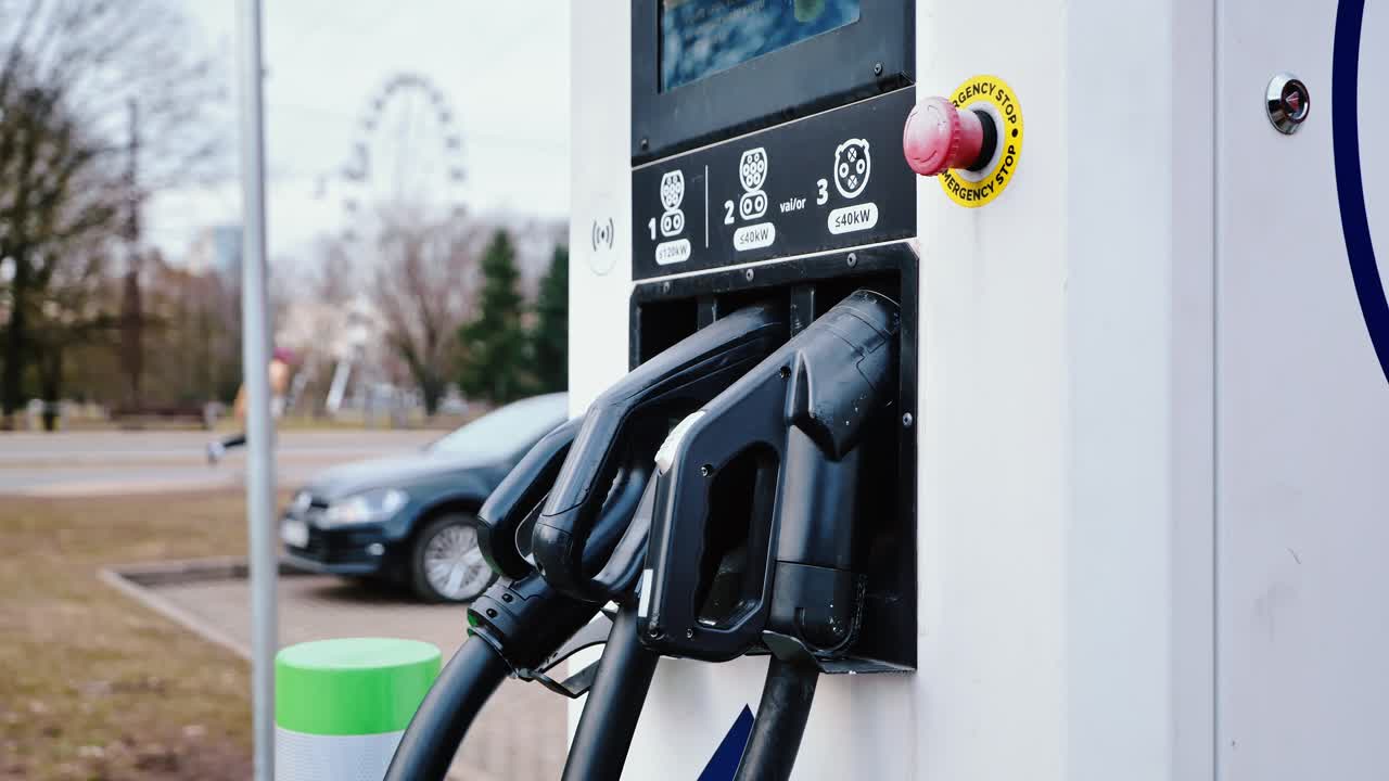 Modern electric charger with skater passing by in Riga spring, slow motion, 4K