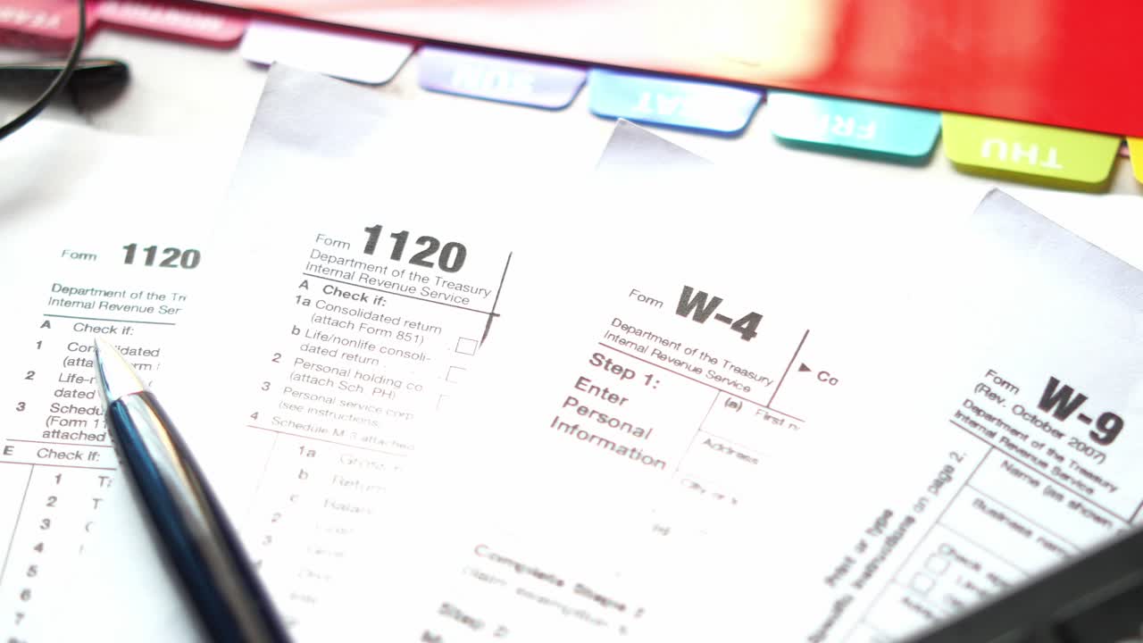 Many us tax form on table , w-9, w-4, 1120 form