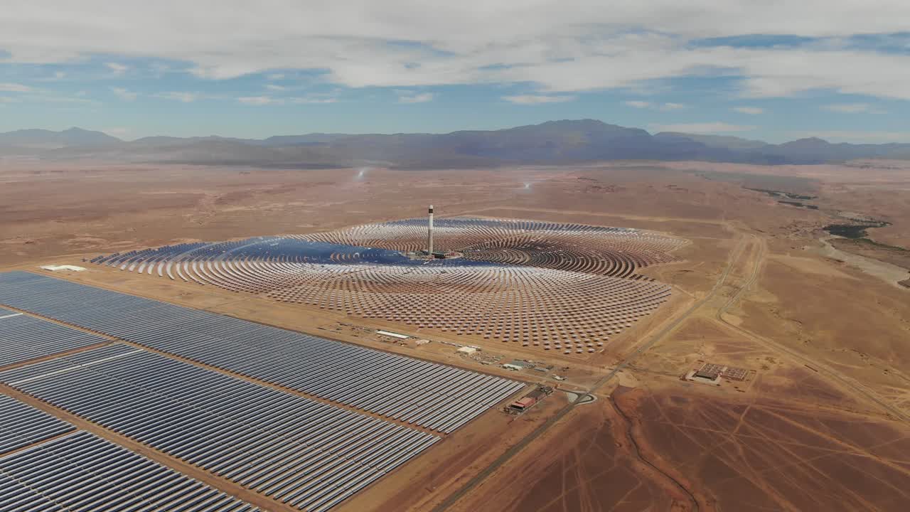 Veduta aerea della centrale solare Noor a Ouarzazate, Marocco, con grandi specchi solari e infrastrutture per l'energia rinnovabile nel paesaggio desertico.