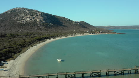 lancha rápida anclada en agua de mar tranquila en el parque nacional de la costa oeste de kraalbaai, sudáfrica - toma aérea