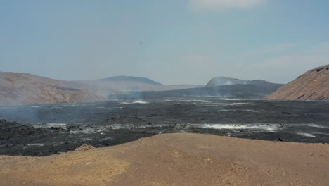 Forwards-fly-above-rugged-surface-of-new-lava-field.-Cooling-and-hardening-layer-of-erupted-magmatic-material.-Fagradalsfjall-volcano.-Iceland,-2021