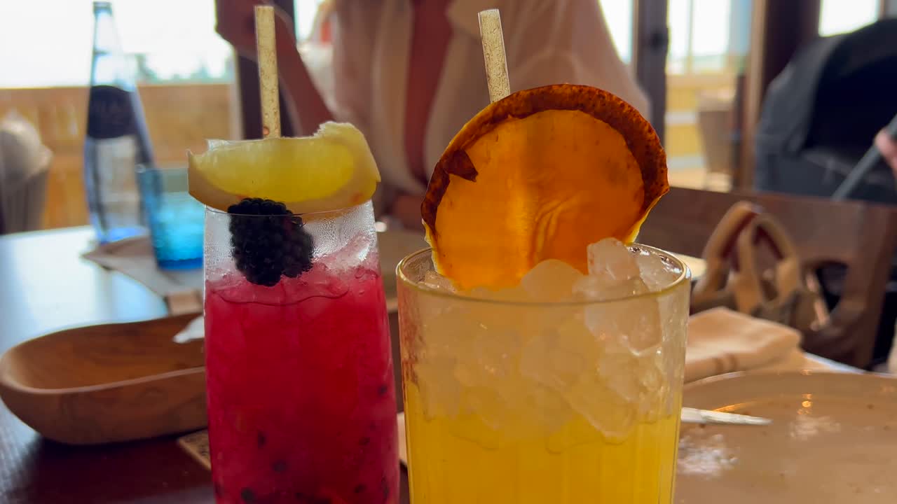 Picking up a delicious summer fruity cocktail in a restaurant, enjoying cold refreshing drinks at a bar, 4K shot