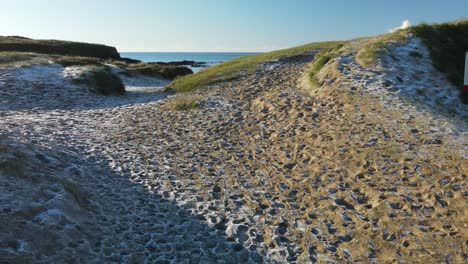 Frozen-sand-on-a-coastal-dunes,-low-flight-aerial-with-no-people