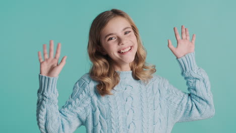 teenage caucasian girl greeting and looking at the camera.