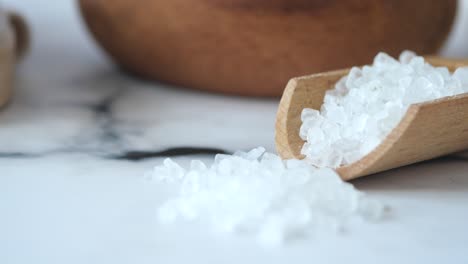 close-up of white sea salt in a wooden scoop