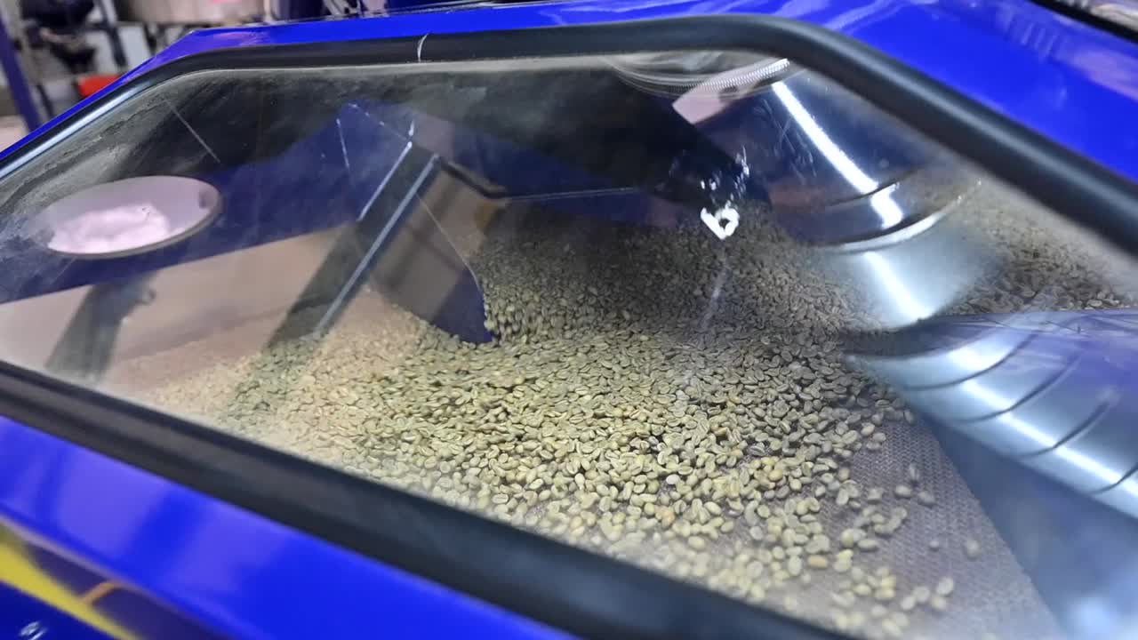 Unroasted raw green coffee beans are dried in the container, coffee industry slow motion