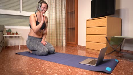 Woman-finishes-online-exercise-class-greets-by-computer-and-leaves