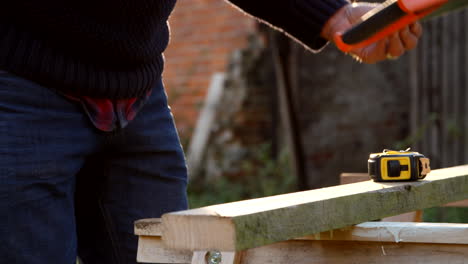 Primer-Plano-Del-Hombre-Midiendo-Y-Aserrando-Madera-En-Cámara-Lenta