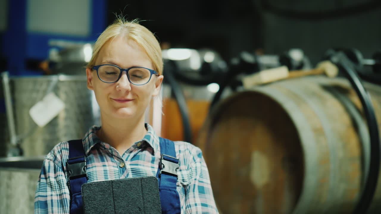 портрет женщины, работающей на винодельне, на фоне винных бочек