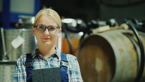 portrait of a woman worker in a winery wine barrels in the background