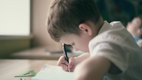 Während-Die-Kinder-Ihre-Hausaufgaben-Machen,-Sitzt-Einer-Mit-Heften-Am-Tisch