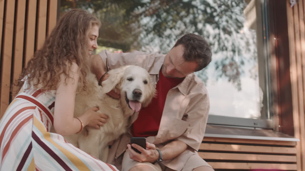 Couple Petting Golden Retriever