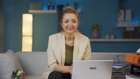 Home-office-worker-woman-talking-facetime-looking-at-camera.