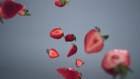 Super-Zeitlupenaufnahme-Von-Frisch-Geschnittenen-Erdbeeren,-Die-Vor-Einem-Hellen-Hintergrund-Fliegen,-Wassertropfen-Spritzen.-Aufgenommen-Mit-Hochgeschwindigkeitskamera.