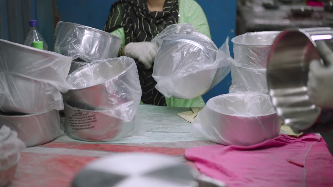 Shining and packing steel pans in a cookware factory