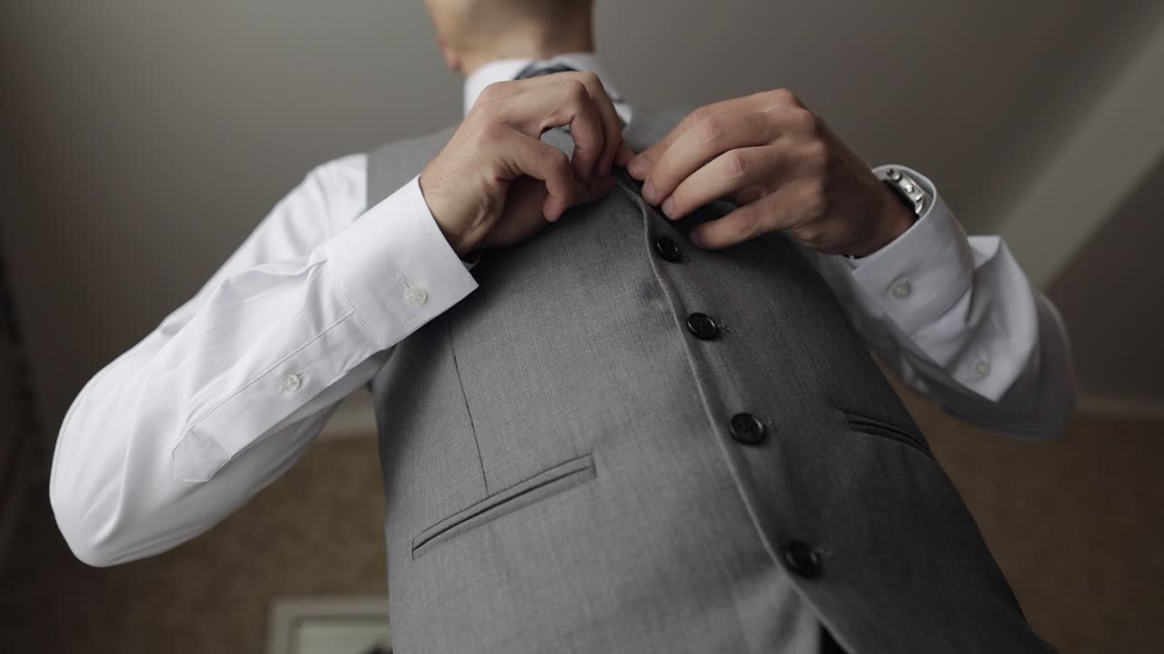 el novio se prepara con traje y corbata.