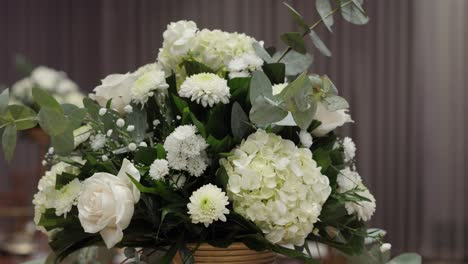 an arrangement of white flowers as a centerpiece for a wedding reception