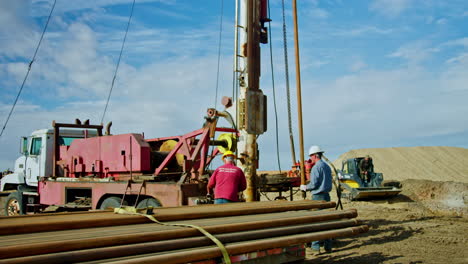 workers arranging equipment for drilling minerals. men work at the site for oil and gas production.
