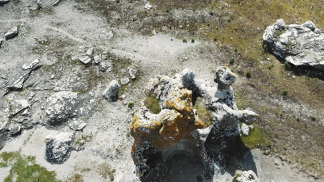 Drone-descending-towards-Rauk-or-sea-stack,-Gotland,-Sweden