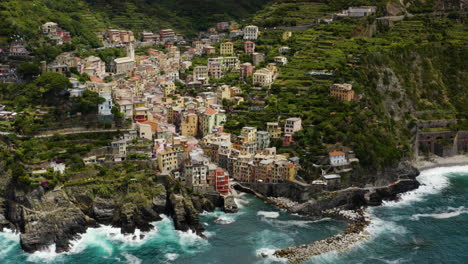 volando hacia el pueblo de riomaggiore en los acantilados de italia